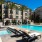 pool with lounge chairs surrounded by trees, cabanas, and tropical landscaping