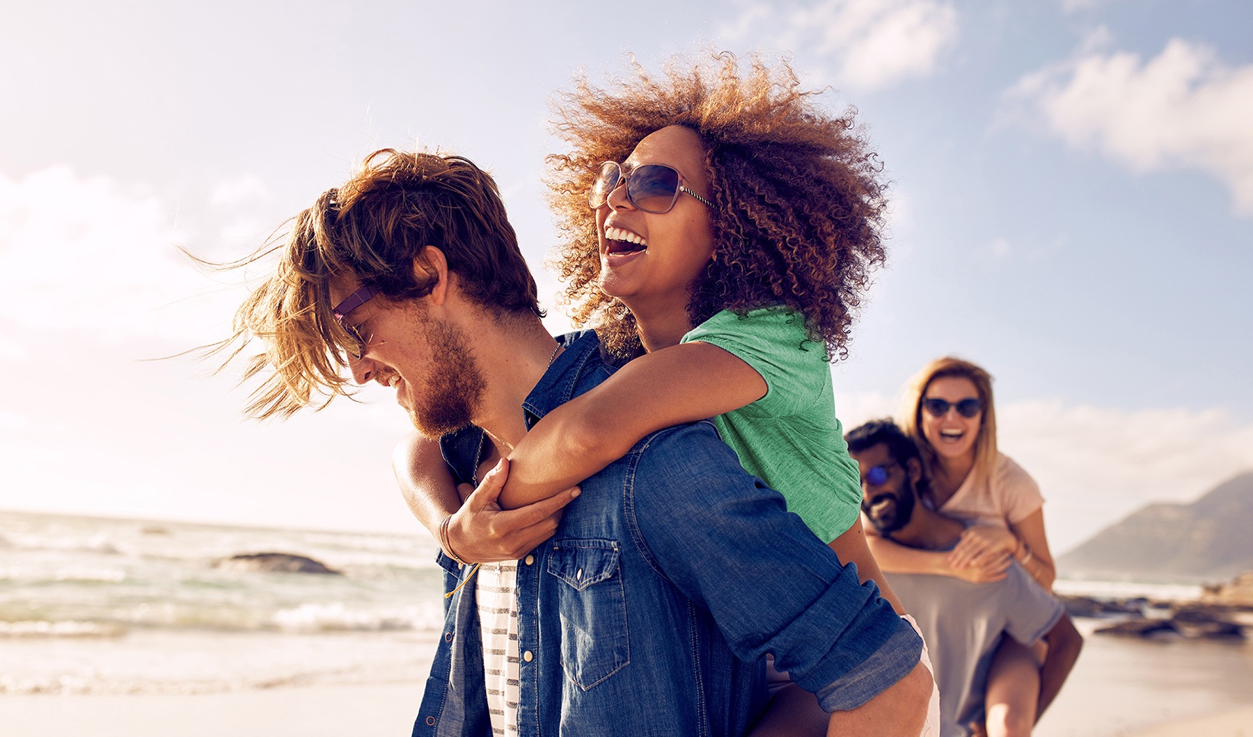 Find Your Happy Place lifestyle image of people piggy-backing on the beach